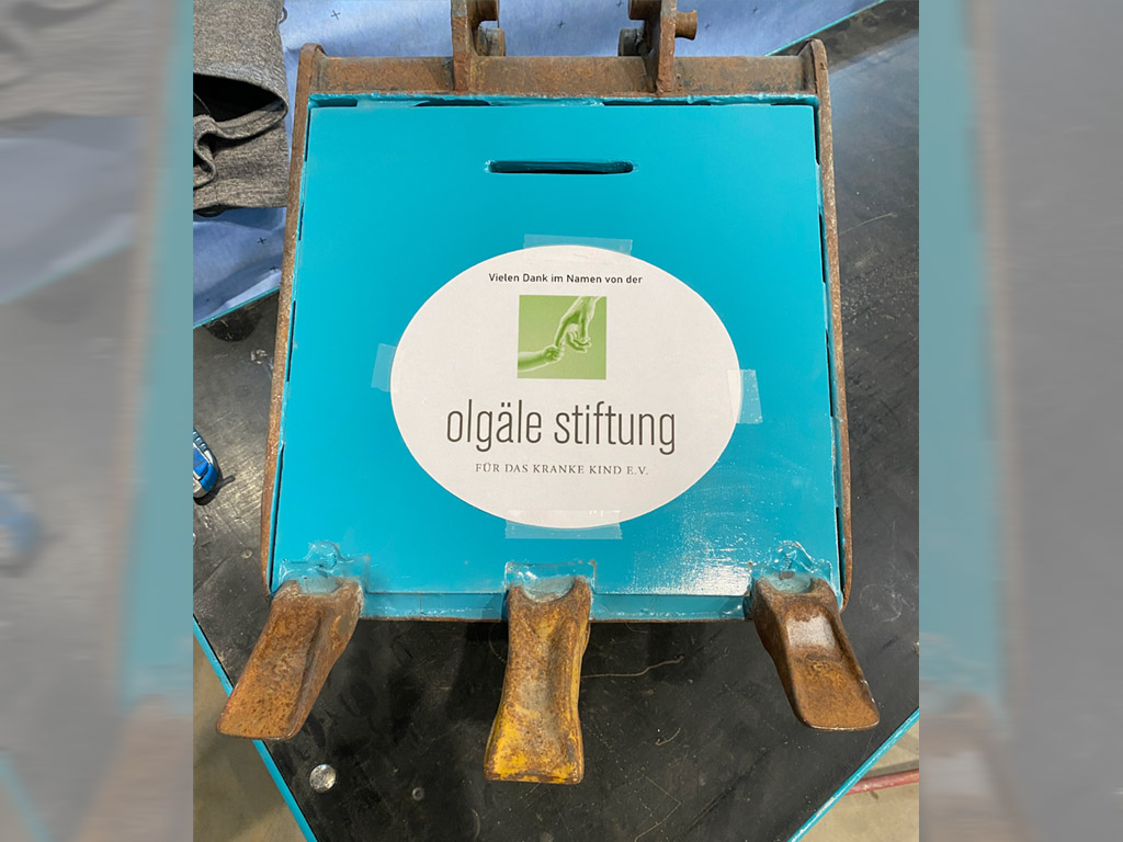 Spende im Kinderbaggerlöffel